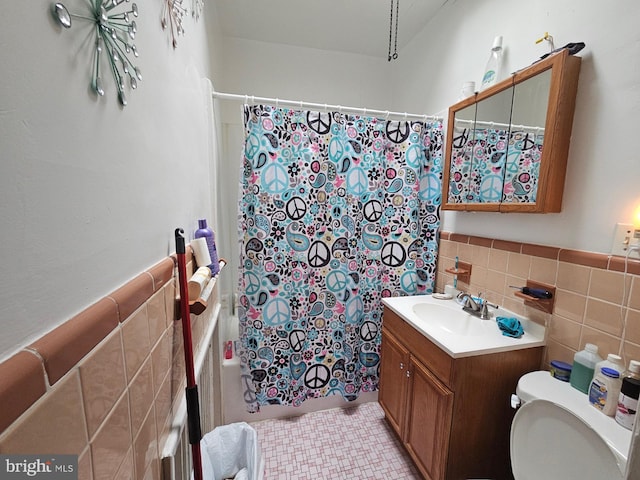 full bathroom featuring tile walls, shower / tub combo with curtain, vanity, and toilet