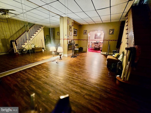 interior space featuring wood-type flooring, ceiling fan, and a paneled ceiling