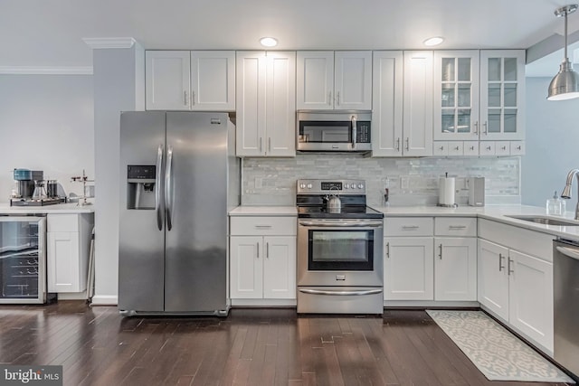 kitchen with white cabinets, decorative light fixtures, stainless steel appliances, and beverage cooler