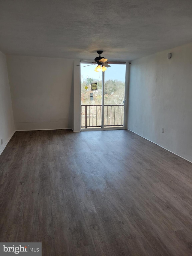 spare room featuring dark hardwood / wood-style flooring and ceiling fan