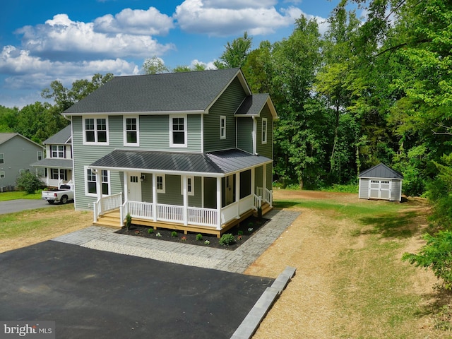 view of front of home featuring a porch and a shed