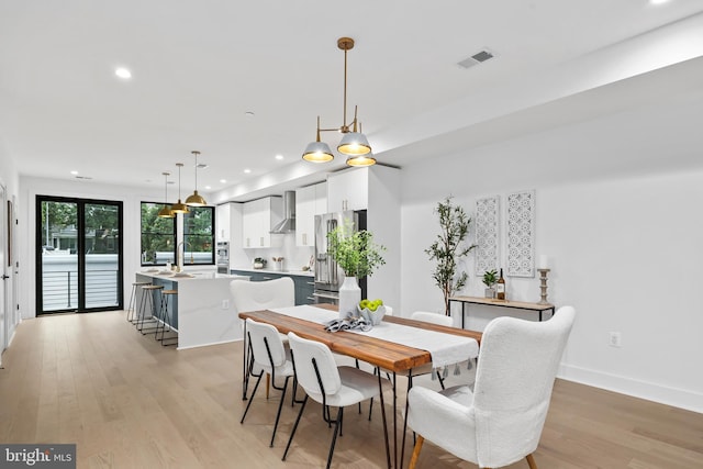 dining area with an inviting chandelier, light hardwood / wood-style flooring, and sink