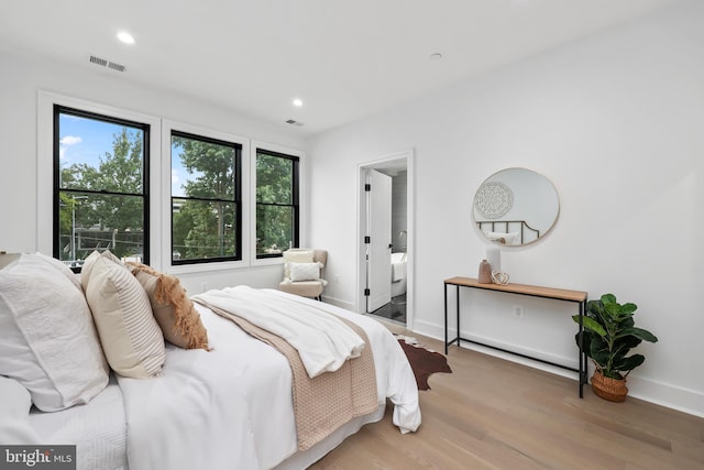 bedroom featuring light hardwood / wood-style floors and ensuite bathroom