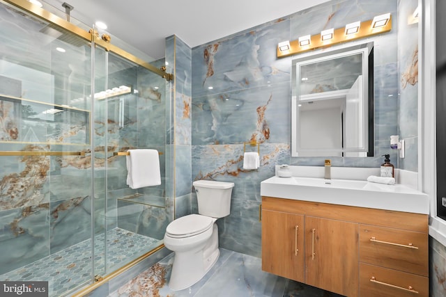 bathroom with tile walls, vanity, toilet, and an enclosed shower