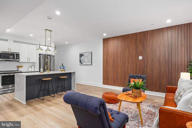 living room featuring light wood-type flooring and wooden walls