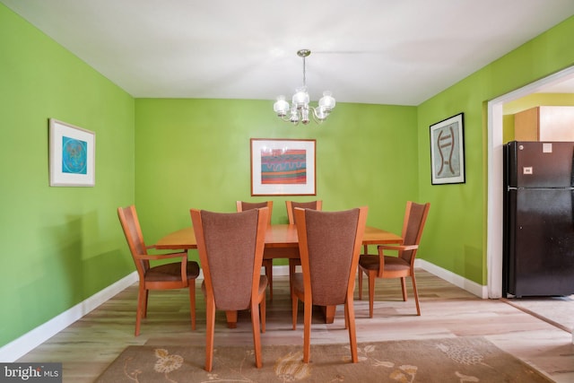 dining room with light hardwood / wood-style flooring and a chandelier