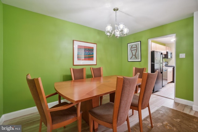 dining space with light wood-type flooring and a chandelier