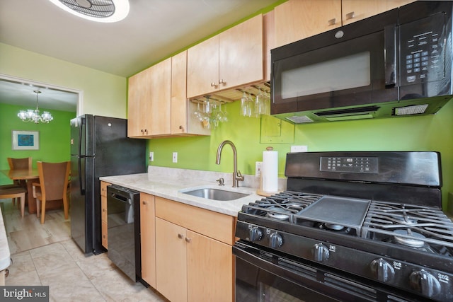 kitchen with black appliances, light brown cabinetry, sink, and a notable chandelier