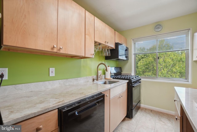 kitchen with black appliances, sink, light tile patterned floors, and light stone countertops