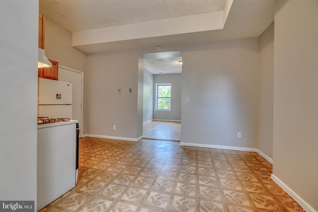 kitchen featuring a textured ceiling, white appliances, and exhaust hood