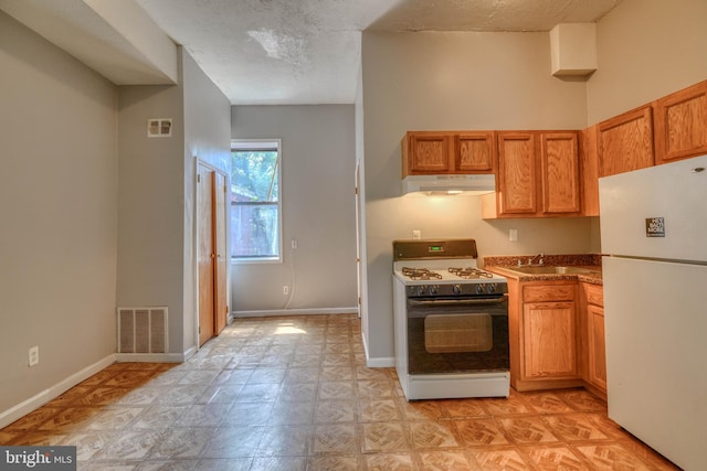 kitchen featuring a textured ceiling, sink, and white appliances