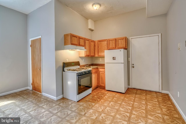 kitchen with a towering ceiling, white appliances, and a textured ceiling