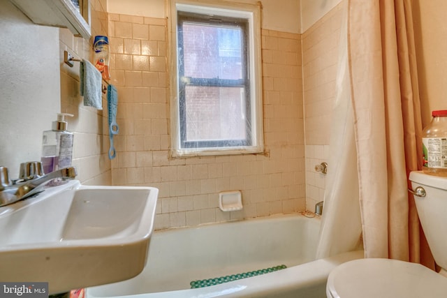 full bathroom with sink, shower / bath combo with shower curtain, and toilet