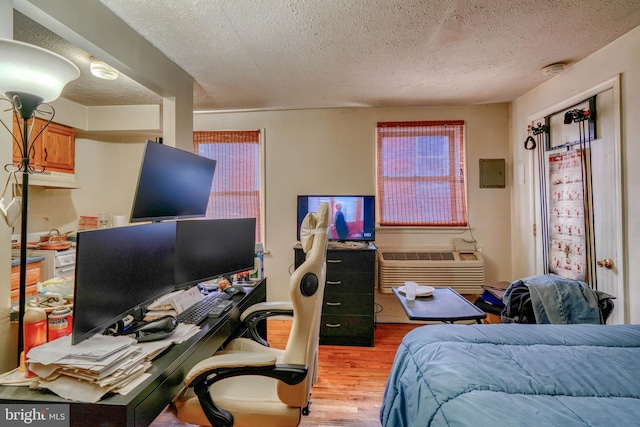 bedroom with a textured ceiling and hardwood / wood-style flooring