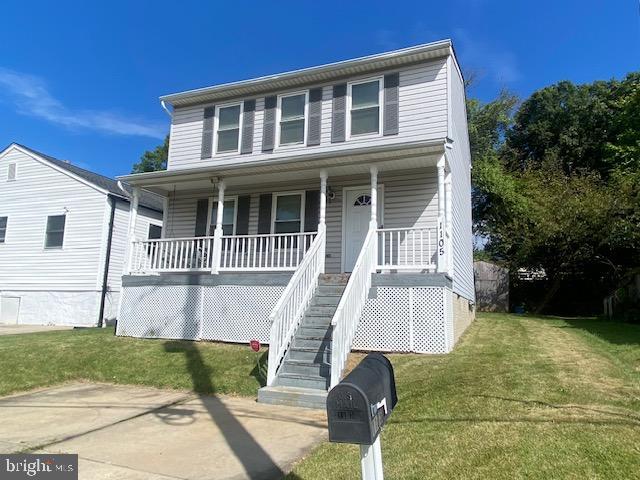 view of front of house with covered porch and a front yard