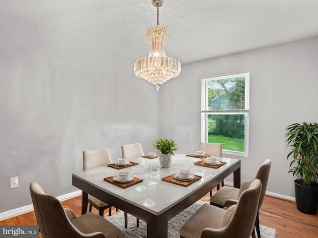 dining area featuring light hardwood / wood-style floors and a notable chandelier