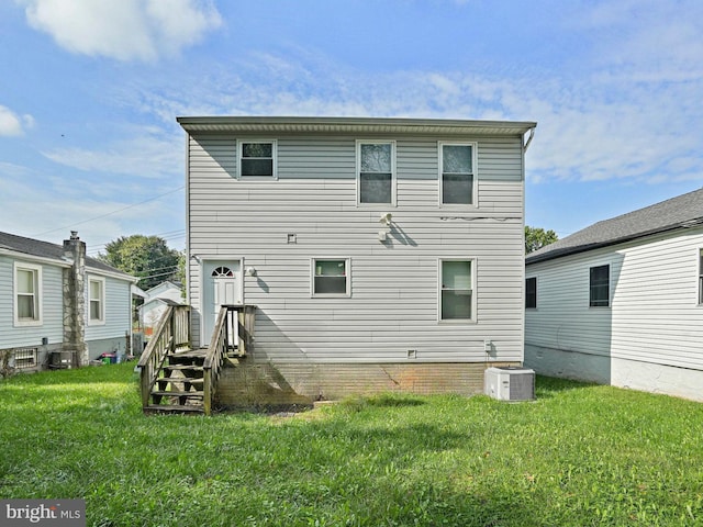 rear view of house with a lawn and central AC