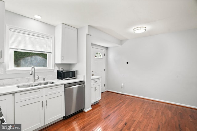 kitchen with stainless steel appliances, dark wood-type flooring, sink, and white cabinetry