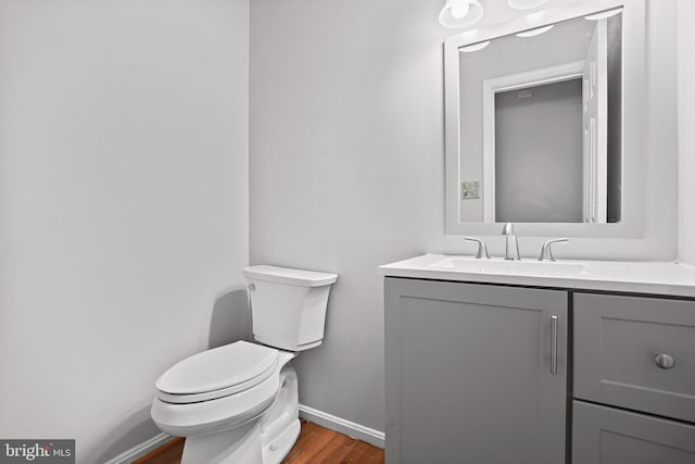 bathroom featuring hardwood / wood-style floors, vanity, and toilet