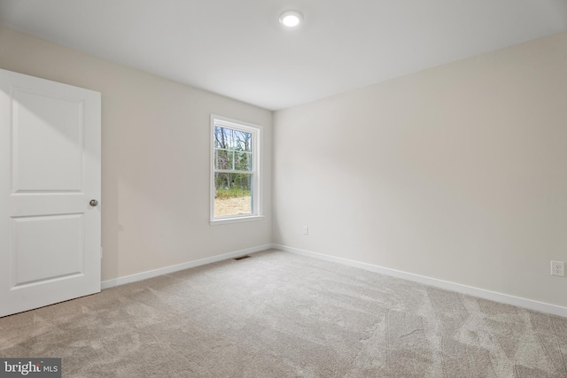 spare room with baseboards, carpet floors, and visible vents