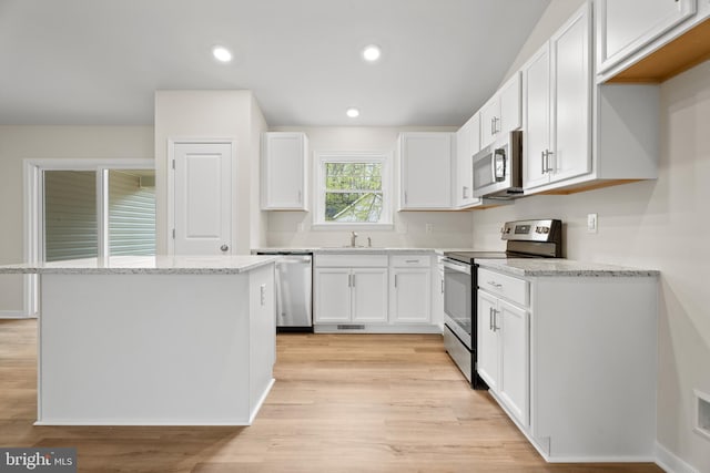 kitchen featuring white cabinets, light stone countertops, stainless steel appliances, and recessed lighting