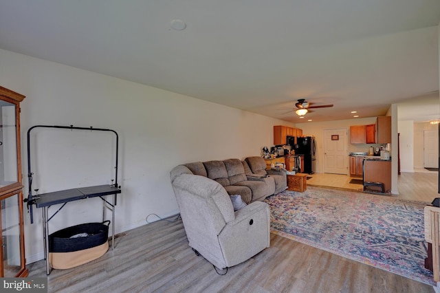 living room featuring light hardwood / wood-style floors and ceiling fan