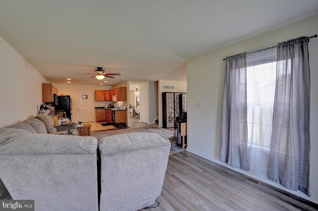 living room with ceiling fan and light hardwood / wood-style floors