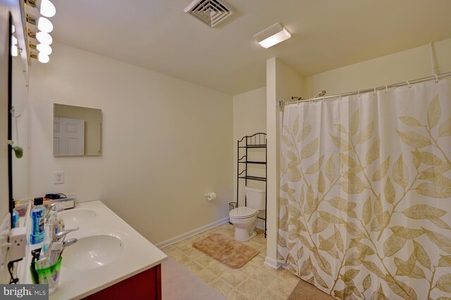 13 Kennison Ln, Dover, DE 19901 - bathroom with visible vents, baseboards, a sink, toilet, and double vanity