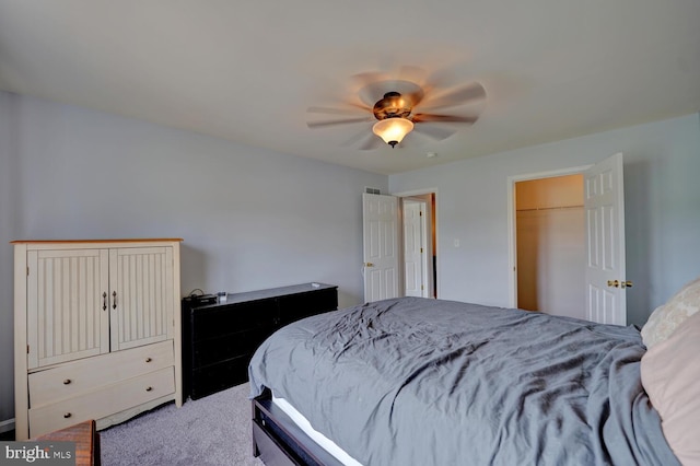 carpeted bedroom featuring a spacious closet, a closet, and ceiling fan