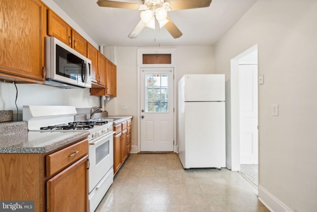 kitchen with white appliances, ceiling fan, and sink