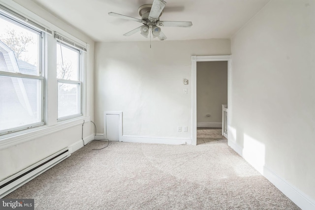 carpeted spare room with ceiling fan and a baseboard heating unit