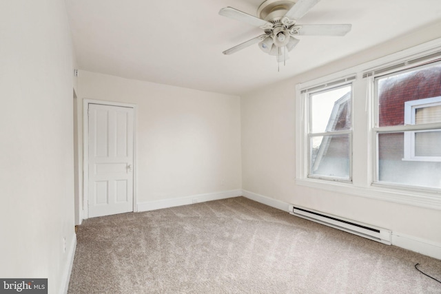 carpeted spare room with ceiling fan and a baseboard radiator