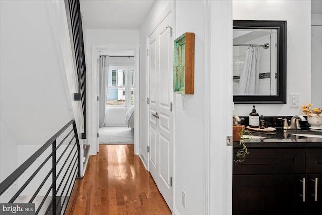 hallway featuring wood-type flooring and sink