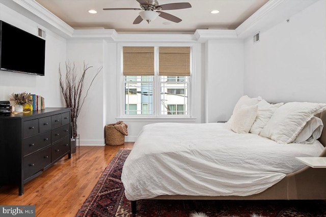 bedroom featuring hardwood / wood-style floors, ceiling fan, and crown molding