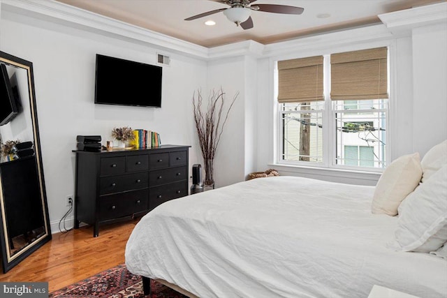 bedroom featuring hardwood / wood-style flooring, ceiling fan, and ornamental molding