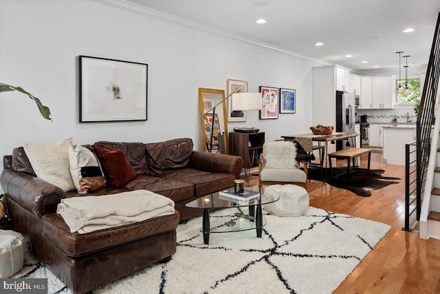 living room featuring ornamental molding and light hardwood / wood-style floors