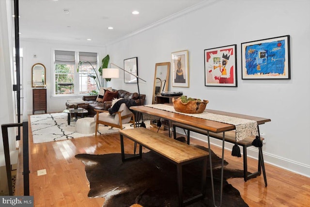 dining space featuring light wood-type flooring and ornamental molding