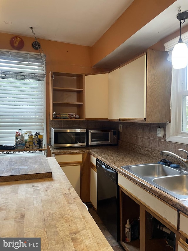 kitchen with pendant lighting, sink, decorative backsplash, and dishwasher