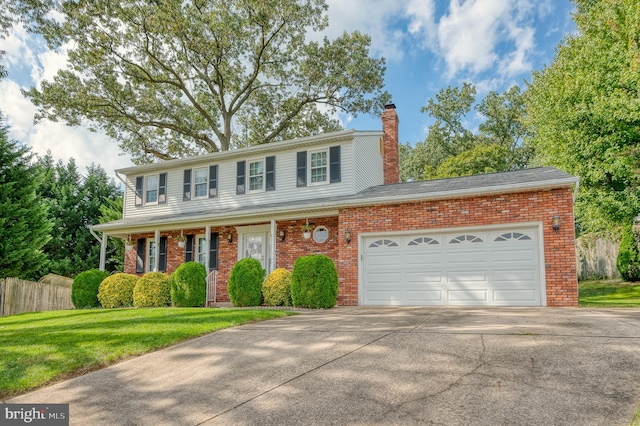 colonial inspired home with a garage and a front yard