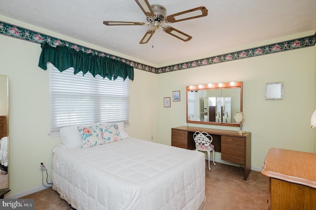 bedroom featuring a textured ceiling, ceiling fan, and light carpet