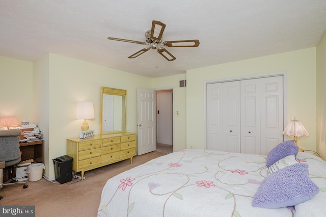 carpeted bedroom featuring ceiling fan and a closet