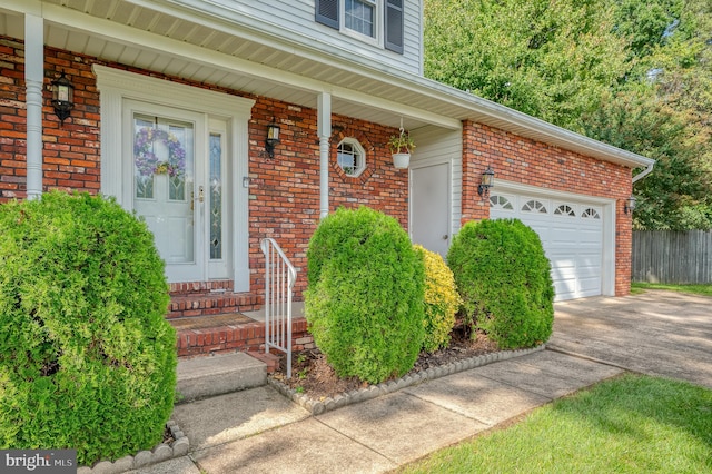 view of exterior entry with a garage and covered porch