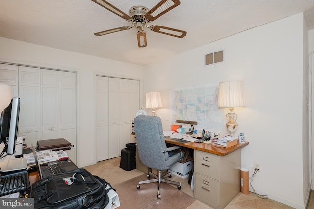 carpeted home office with ceiling fan