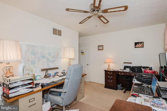 carpeted home office featuring ceiling fan