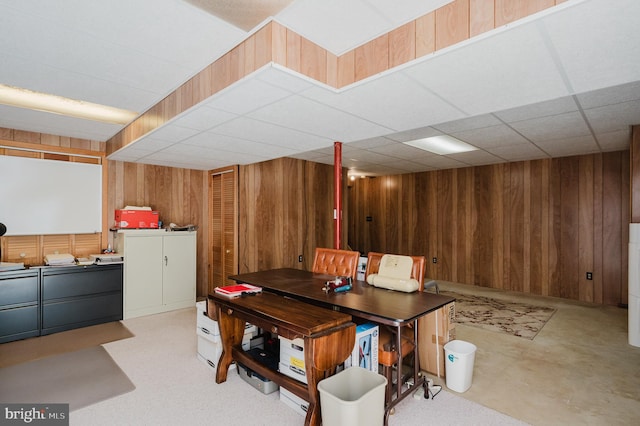 dining area with wooden walls and a paneled ceiling