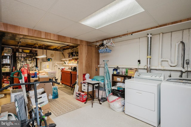 basement featuring a paneled ceiling and washer and dryer