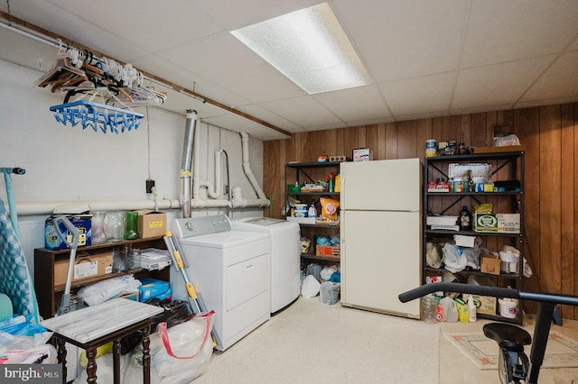 washroom featuring wooden walls and washing machine and clothes dryer