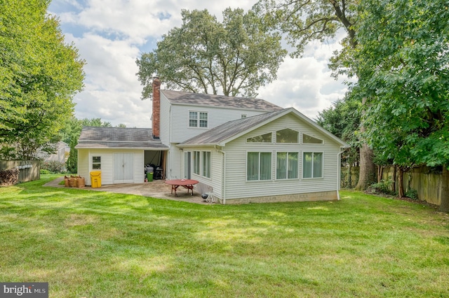 rear view of property with a lawn and a patio area