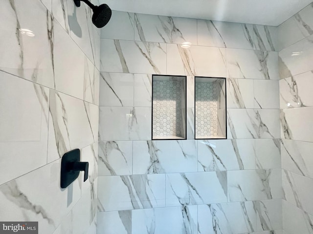 interior details featuring tiled shower