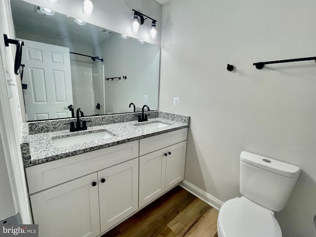 bathroom with a shower, wood-type flooring, vanity, and toilet